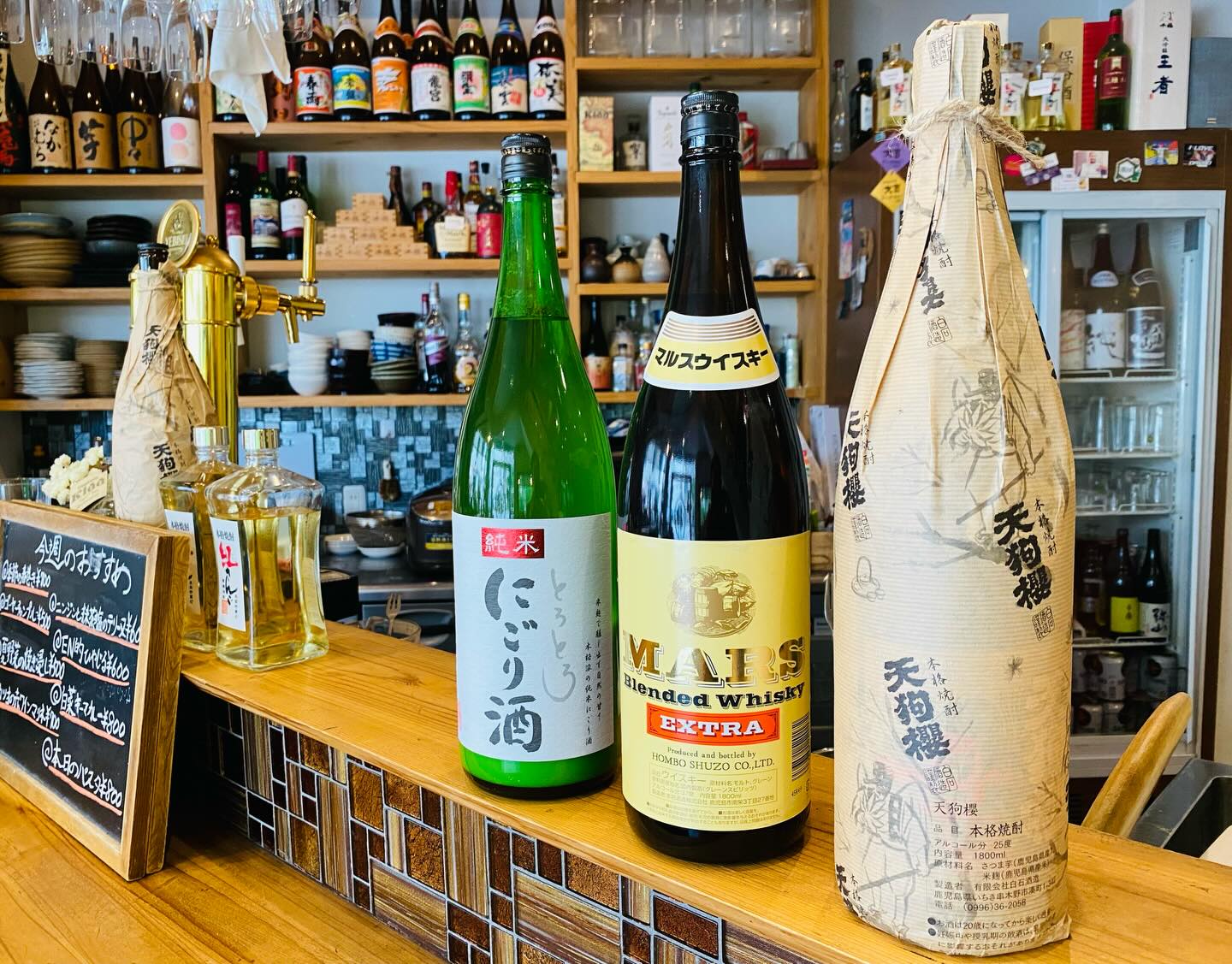 カウンターに並ぶ焼酎、にごり酒、ウイスキー。