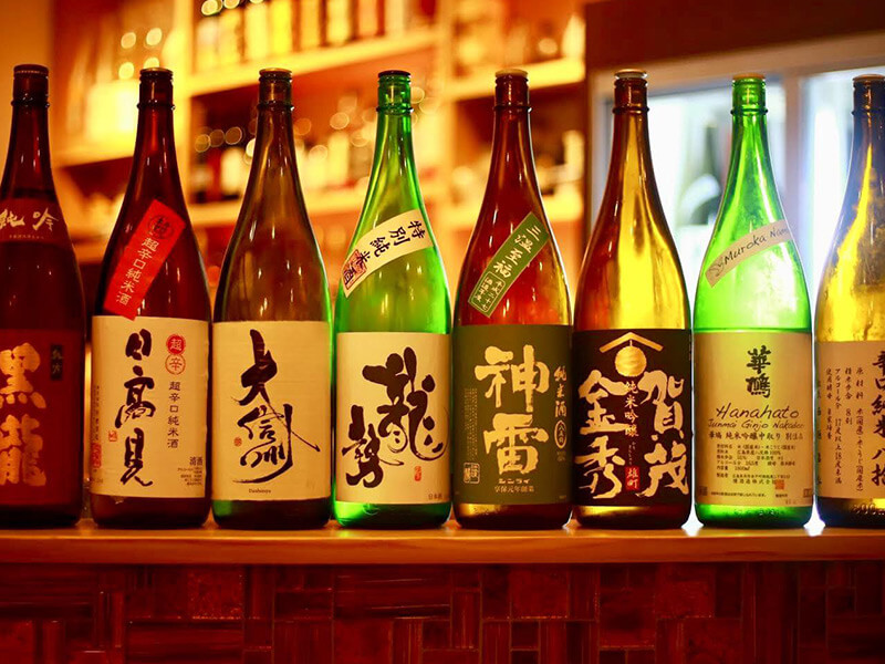 バーであたたかく光る日本酒の瓶。